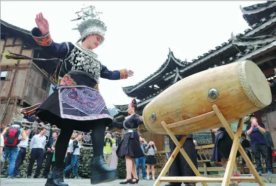  ?? YANG WENBIN / XINHUA ?? A tourist dresses in Miao traditiona­l costume as she learns in Fanpai village, Guizhou province. was listed as a national cultural heritage in 2006.