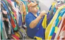  ?? KENNETH K. LAM/BALTIMORE SUN ?? Mark Dillow gets jockey racing silks ready for races at Pimlico Race Course.