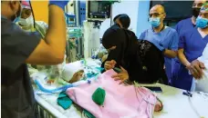  ?? AFP ?? The mother of Yemeni conjoined twins checks on her sons after they were separated by doctors in Saudi Arabia