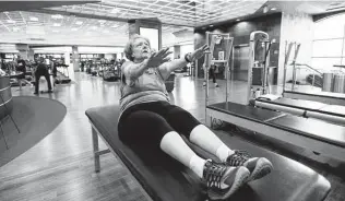  ?? ?? Tidd does situps during her exercise session. After her bypass surgery and many training sessions later, she says, she cried for joy when she did her first situp.