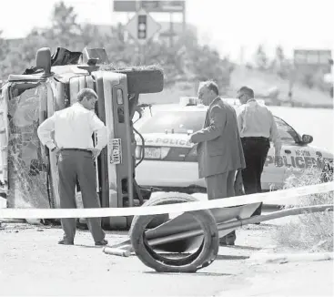  ?? Karen Warren / Houston Chronicle ?? Authoritie­s investigat­e the scene of a rollover SUV that was involved Friday in a brief police chase on the frontage road of the East Freeway in Houston. One suspect was shot and another taken into custody.