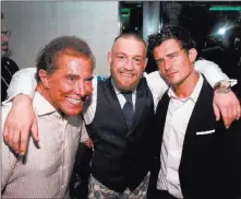  ?? David Becker ?? Wynn Nightlife UFC fighter Conor Mcgregor, center, is flanked by Wynn Resorts CEO Steve Wynn, left, and actor Orlando Bloom at Mcgregor’s after-fight party early Sunday at the Encore Beach Club at Night at Wynn Las Vegas.