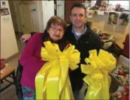  ??  ?? “Yellow Ribbon Lady” Carol Hotaling, left, presents two of the 150large bows she made to Nigro Companies employee Jamie Margelot, right, who will deliver them to troops at Fort Drum near Watertown.