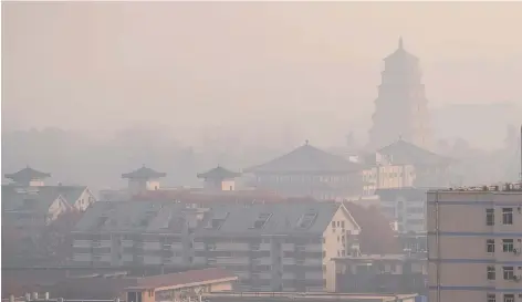  ?? ?? Buildings are shrouded in fog in Xi’an City, the capital of northwest China’s Shaanxi Province, yesterday. — CFP