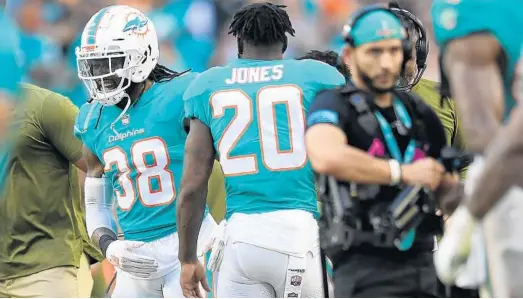  ?? JIM RASSOL/SUN SENTINEL ?? Reshad Jones stands on the sidelines during Sunday’s game against the Jets. He pulled himself from the game because he did not want to be a part of the secondary rotation.