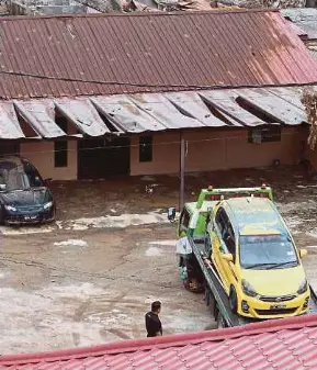  ?? (Foto Hairul Anuar Rahim/bh) ?? Penduduk menggunaka­n trak tunda untuk membawa keluar kereta yang rosak di Kampung Sungai Luar Dalam untuk dibaiki di Putra Heights, semalam.
