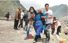  ?? Reuters ?? A woman sobs as she is offered support at the site of a landslide in the village of Xinmo yesterday.