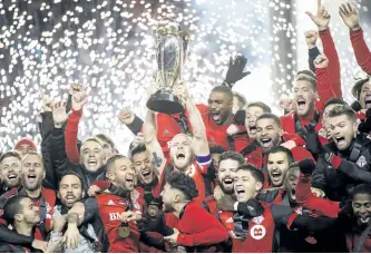  ?? NATHAN DENETTE/THE CANADIAN PRESS ?? Toronto FC midfielder Michael Bradley, centre, hoists the MLS Cup with teammates after defeating the Seattle Sounders during MLS Cup soccer action, in Toronto, on Saturday, Dec. 9.