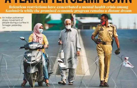  ?? AFP ?? An Indian policeman stops movement of people during a curfew in Srinagar yesterday.