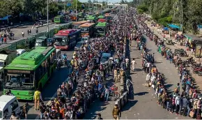  ?? GETTY IMAGES ?? Crowds of Indian migrant workers wait to board buses to return to their native villages as a nationwide lockdown continues in Ghaziabad, on the outskirts of New Delhi.