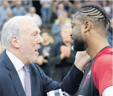  ?? DARREN ABATE/AP ?? Heat guard Dwyane Wade accepts a gift from Spurs coach Gregg Popovich before a game Wednesday in San Antonio.