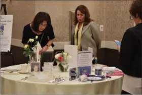  ?? MARIAN DENNIS — DIGITAL FIRST MEDIA ?? Attendees at Wednesday’s Break the Silence luncheon take a look at a set table dedicated to victims lost to domestic abuse. The event, hosted by Laurel House is held annually.