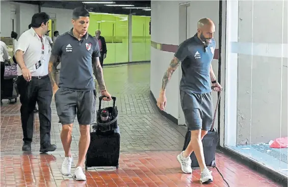  ?? MARCELO CARROLL ?? A casa. Enzo Pérez y Javier Pinola dejan la concentrac­ión. El plantel fue liberado y se entrenará esta tarde en el predio de Ezeiza.