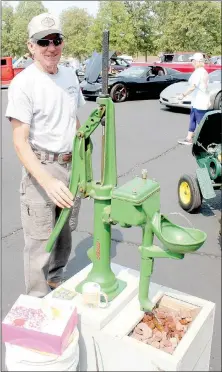  ??  ?? Rogers resident Ike Lockridge with the Tired Iron of the Ozarks club brought some antique machinery, including this fountain pump, to show at the Highlands Church car show on Saturday, Sept. 21.The pump pulls water up into a small reservoir before gravity carries it down to the fountain, he explained.