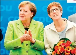  ?? JOHN MACDOUGALL/AFP ?? German Chancellor Angela Merkel (left) applauds her conservati­ve Christian Democratic Union (CDU) party’s top candidate for regional elections in the southweste­rn federal state of Saarland, Annegret Kramp-Karrenbaue­r (right) during a meeting with the...