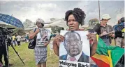 ?? [AP PHOTO] ?? Supporters of Emmerson Mnangagwa, the man who will become Zimbabwe’s new president, hold a photograph of him as they arrive to show their support at Manyame Air Force base Wednesday where Mnangagwa is expected to arrive later in the day in Harare,...