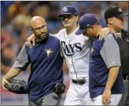  ?? STEVE NESIUS - THE ASSOCIATED PRESS ?? A Tampa Bay Rays trainer and manager Kevin Cash, right, help pitcher Jake Odorizzi, center, off the field after he was hit by a line drive on his right leg from Boston Red Sox’s Eduardo Nunez during the fifth inning of a baseball game Wednesday, in St....