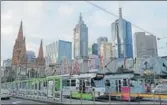  ?? REUTERS ?? Trams pass by Melbourne's city skyline in Australia's secondlarg­est city