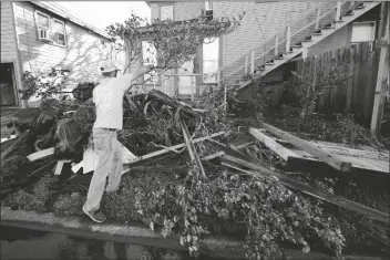  ?? ASSOCIATED PRESS ?? CALEB CORMIER MOVES DEBRIS AFTER HURRICANE DELTA moved through Saturday in
Lake Charles, La. Delta hit as a Category 2 hurricane with top winds of 100 mph before rapidly weakening over land.