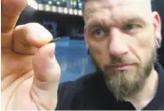  ?? James Brooks / Associated Press ?? Jowan Osterlund of Biohax Internatio­nal holds a microchip. Three Square Market in Wisconsin is offering to implant the chips in employees’ hands.