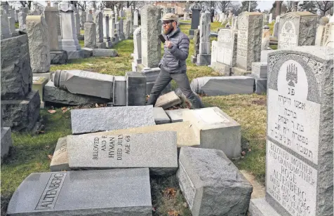  ?? JACQUELINE LARMA, AP ?? Rabbi Joshua Bolton of the University of Pennsylvan­ia surveys damaged headstones at Mount Carmel Cemetery on Monday in Philadelph­ia. More than 100 headstones were vandalized at the Jewish cemetery.
