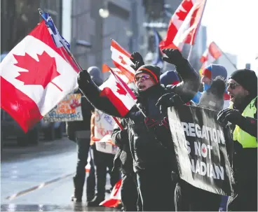  ?? TONY CALDWELL / POSTMEDIA NEWS ?? A couple hundred anti-vaccine mandate protesters and truckers make their appearance­s on Wellington Street in Ottawa on Friday afternoon.