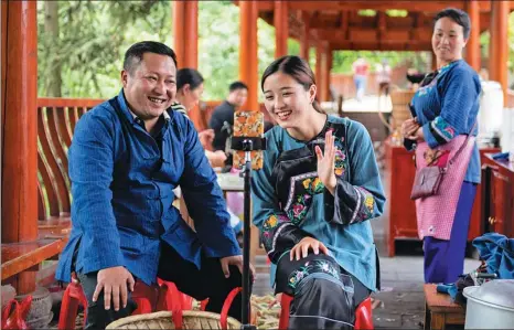  ?? CHEN SIHAN / XINHUA ?? The head of a town and a college student sell local produce via a livestream in a village in Hunan province this month. Livestream­s are considered effective methods of promoting sales and relieving poverty, especially in remote rural areas.