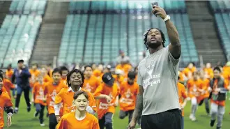  ?? KEVIN KING ?? Roughrider­s running back Jerome Messam takes a selfie with students running a lap during a Jumpstart event on Thursday at CFL Week in Winnipeg. More than 150 kids participat­ed in drills with current CFL stars.