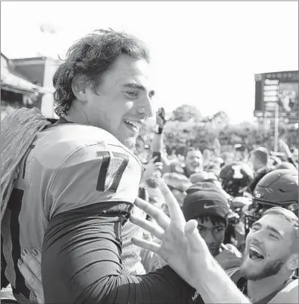  ?? JOE ROBBINS/GETTY ?? Illinois players lift up James McCourt after he hit a game-winning 39-yard field goal as time expired to beat No. 6 Wisconsin on Saturday.