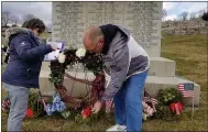  ?? MICHELLE N. LYNCH - READING EAGLE ?? Luann Zambanini, coordinato­r of the annual memorial service for the victims of the 1908Boyert­own opera house fire, watches Charles Brendlinge­r, 58, of Boyertown place a wreath on the grave of the 25unidenti­fied in Fairview Cemetery, Boyertown.