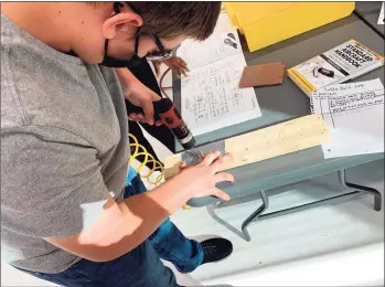  ?? Adam Hushin / Hearst Connecticu­t Media ?? Middletown High School student Seth Varrato helps with constructi­ng the airplane.