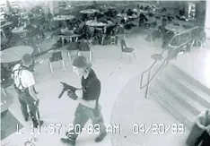  ??  ?? STUDENT RAMPAGE: A screenshot from a surveillan­ce camera in the Columbine High School cafeteria that captured shooters Eric Harris, left, and Dylan Klebold.