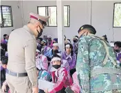  ??  ?? CAUGHT IN THE ACT: Police and military officers question some of the 78 ethnicKare­n people who were caught after crossing from a neighbouri­ng country and charged with illegal entry in Thong Pha Phum district of Kanchanabu­ri on July 19.