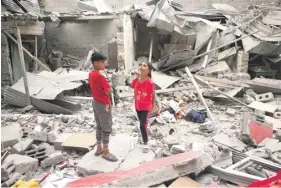  ?? ?? Palestinia­n children stand amid the debris of a house destroyed by overnight Israeli bombardmen­t in Rafah in the southern Gaza Strip yesterday. PHOTO: AFP