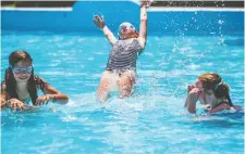  ??  ?? Friends Violet Anderson, 9, Rose Lumley, 10, and Lilia Moon, 10, cool off Tuesday in the wading pool at Hampton Park. ASHLEY FRASER