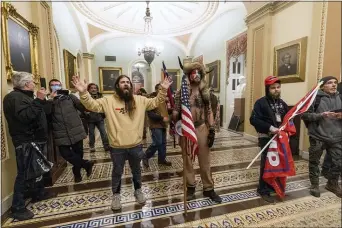  ?? MANUEL BALCE CENETA — THE ASSOCIATED PRESS FILE ?? In this Wednesday, Jan. 6, 2021 file photo supporters of President Donald Trump are confronted by U.S. Capitol Police officers outside the Senate Chamber inside the Capitol in Washington. Jacob Anthony Chansley, the Arizona man with the painted face and wearing a horned, fur hat, was taken into custody Saturday, Jan. 9, 2021 and charged with counts that include violent entry and disorderly conduct on Capitol grounds.