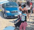  ?? CHRISTINE AYALA THE CANADIAN PRESS ?? People look on after a van was driven on to the beach in Port Dover on Saturday. A 43-year-old man was charged with impaired driving.