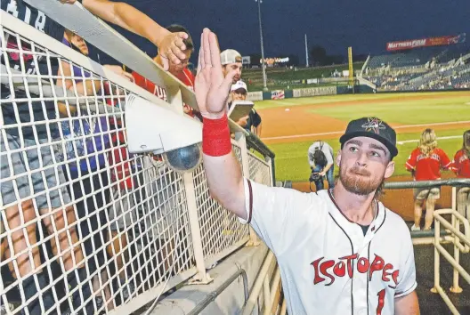  ?? Jim Thompson, Albuquerqu­e Journal ?? Brendan Rodgers gives a high five to a young fan before the start of his first Triple-A game with the Albuquerqu­e Isotopes last August. Friday likely will be another first — his first major-league game with the Rockies against the Philadelph­ia Phillies.