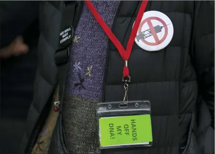  ?? AP PHOTO/EDUARDO MUNOZ ALVAREZ ?? A woman wears an anti-vaccine pin while people and teachers pray as they protest against Covid-19vaccine mandates outside the Manhattan Federal Court Tuesday, Oct. 12, 2021, in New York.