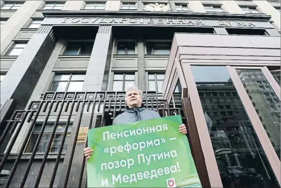  ?? MAXIM SHEMETOV / REUTERS ?? Serguéi Mitrojin, de Yábloko, junto a la Duma el miércoles. Su cartel dice: “La reforma de las pensiones una vergüenza de Putin y Medvédev”