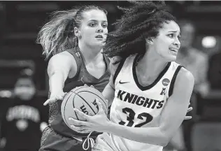  ?? Jessica Hill / Associated Press ?? Central Florida’s Brittney Smith, right, is guarded by Florida’s Kristina Moore during Saturday’s game in Storrs, Conn. UCF beat the Gators for the first time after 26 consecutiv­e losses.