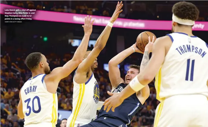  ?? HARRY HOW/GETTY IMAGES ?? Luka Doncic gets a shot off against Stephen Curry, Otto Porter Jr. and Klay Thompson en route to 42 points in a losing effort Friday.