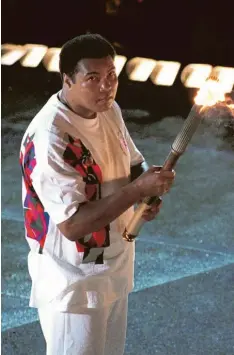  ?? Foto: imago ?? Mit beiden Händen hält Muhammad Ali die Fackel, mit der er 1996 in Atlanta das olympische Feuer entzündet.