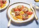  ?? SCOTT SUCHMAN/FOR THE WASHINGTON POST ?? Citrus juice and segments come together in with sautéed shallots and white wine to form a stunning, slurpy, sweettart sauce that is poured over seared scallops.