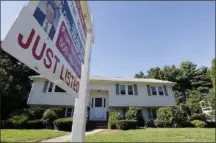  ?? AP FILE PHOTO ?? A for sale sign hangs in front of a house.