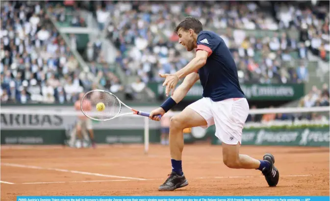  ?? — AFP ?? PARIS: Austria’s Dominic Thiem returns the ball to Germany’s Alexander Zverev during their men’s singles quarter-final match on day ten of The Roland Garros 2018 French Open tennis tournament in Paris yesterday.