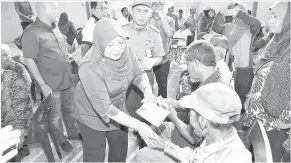  ??  ?? ROHANI (kiri) menyampaik­an sumbangan kepada salah seorang mangsa banjir di Sebuyau.