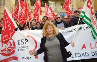  ?? — AFP ?? Spanish hotel maid Pepita Garcia Lupianez holds union flags as she takes part in a protest against a reform of Spain’s labor code in 2012, which maids say has led to lower salaries, in Malaga on Dec 15, 2016.