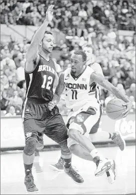  ?? FRED BECKHAM/ASSOCIATED PRESS ?? Connecticu­t’s Ryan Boatright, driving past Bryant’s Dyami Starks, had 24 points and eight rebounds to lead the defending national champion Huskies to a season- opening victory.
