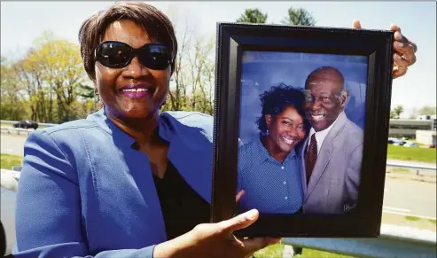  ?? Ned Gerard / Hearst Connecticu­t Media ?? Jolyn Walker holds a portrait of herself and her late husband, Judge, during an interview in Milford on Wednesday. Judge Walker, a Milford firefighte­r, died in 2018.